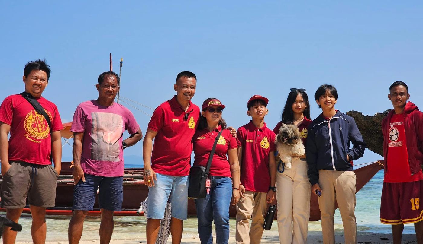 The Jazul team in red company shirts on a beach in Aroroy